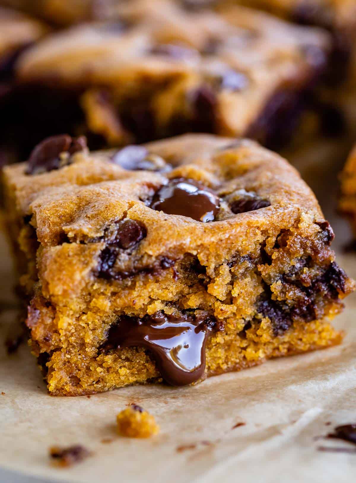 a slice of pumpkin blondies with chocolate oozing out the side