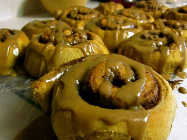 Many pumpkin cinnamon rolls frosted