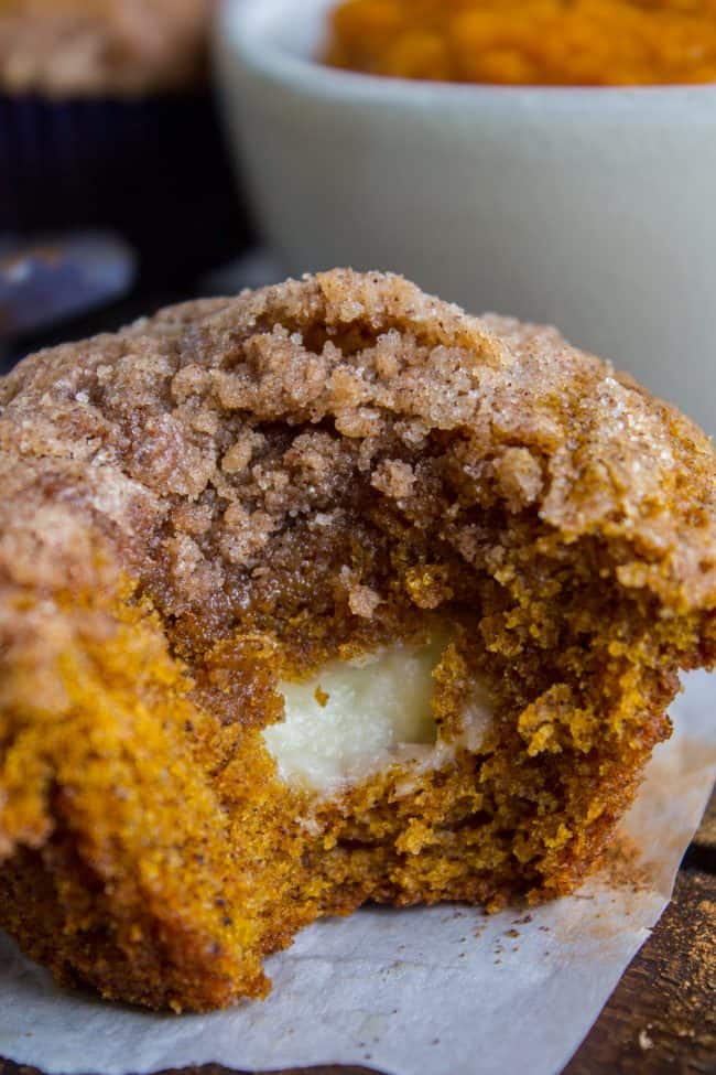 side view of a cream cheese pumpkin muffins with a bite taken out.