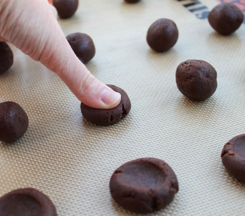 Thumb pressing down chocolate cookie dough