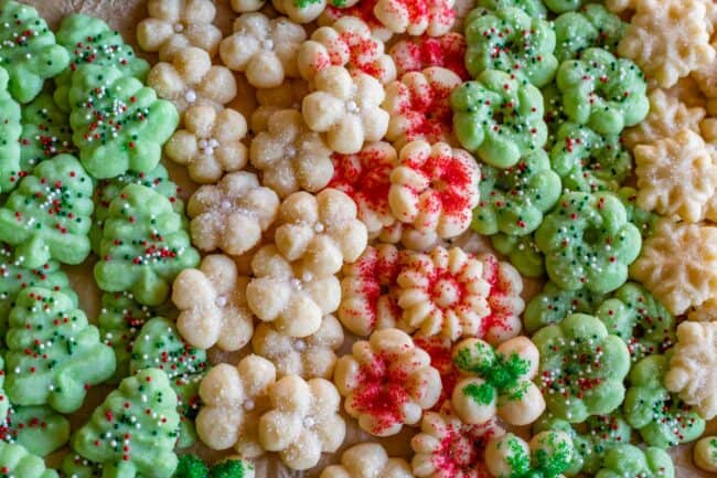dozens of green, red, and white sprinkle decorated spritz cookies.
