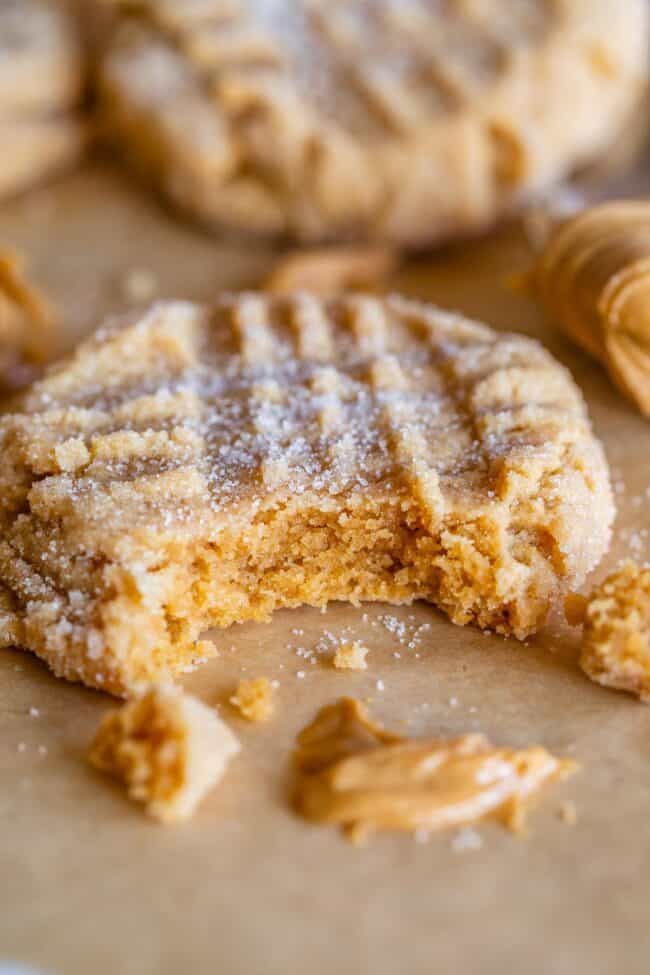 soft peanut butter cookies, one with a bite taken out and a smear of peanut butter on tray.