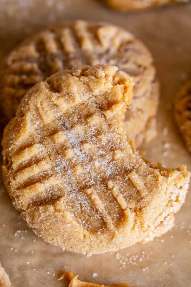 chewy peanut butter cookie tilted on its side with a bite taken out.