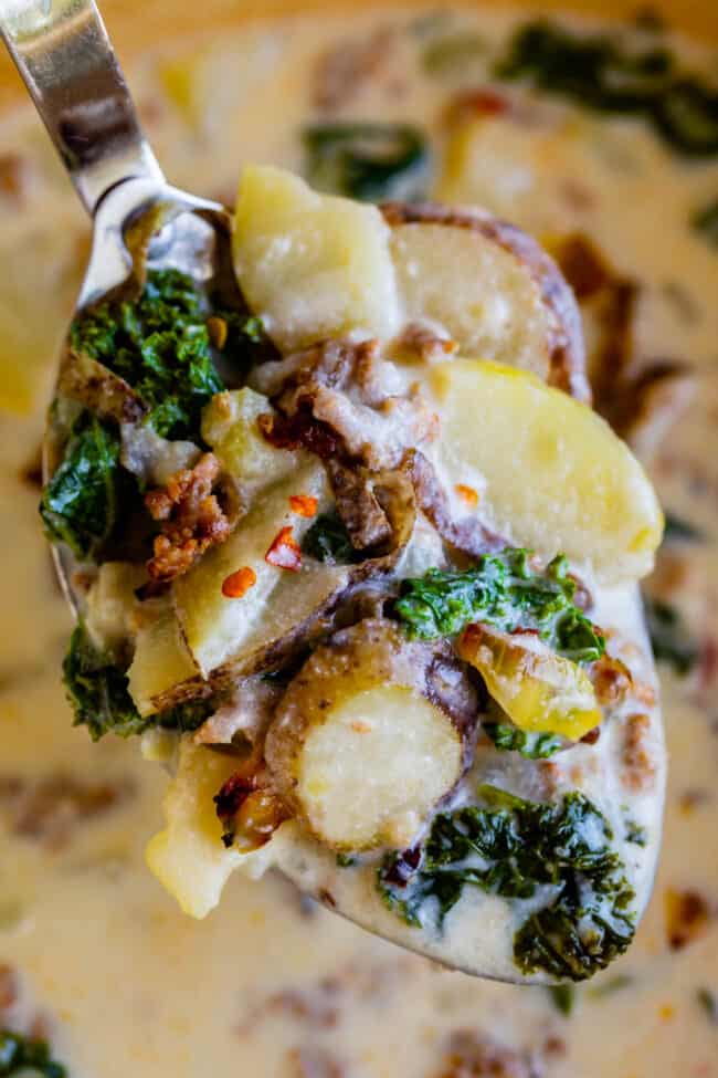 zuppa toscana soup recipe held up on a serving spoon with potatoes kale and sausage