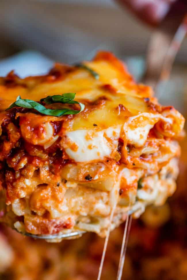 a slice of baked ziti lifted by a serving spoon.