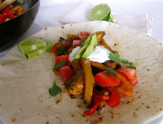 Vegetarian chickpea and pepper fajitas with sour cream and avocado.