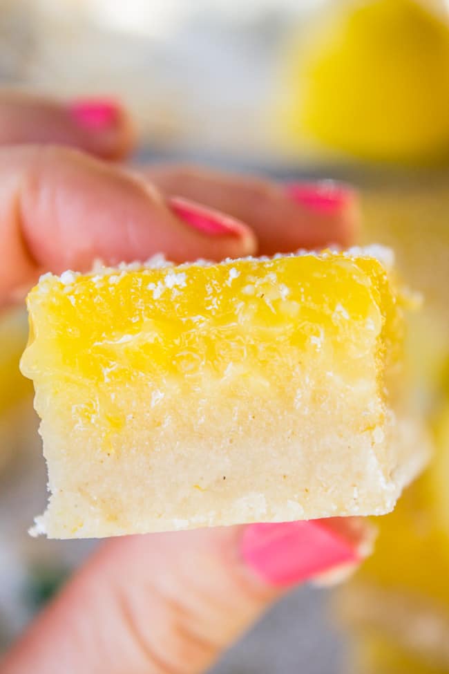 a hand holding a super thick lemon bar.