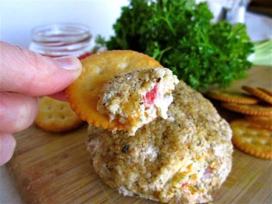 Ritz cracker with bit of cheese ball in foreground.