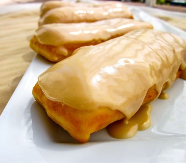 maple bar donut with maple glaze on a plate with more in the background