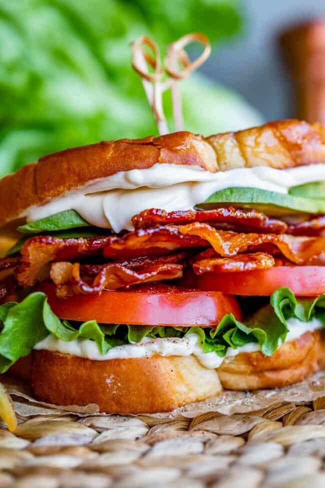 blt sandwich on parchment paper with toothpicks holding it together