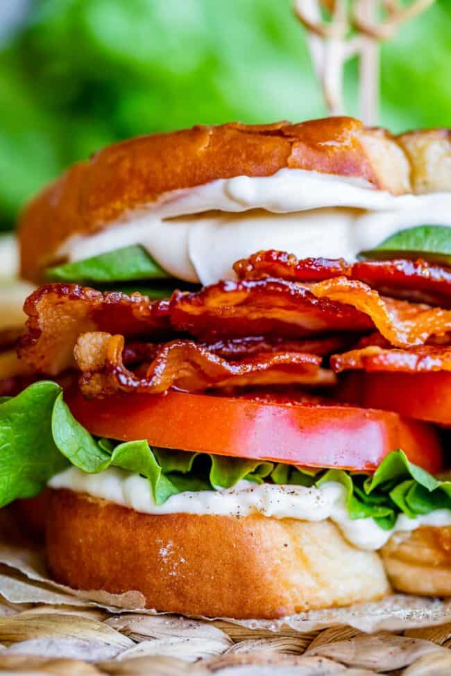 Close up of a BLT with bacon, lettuce, tomato, mayo, and avocado.