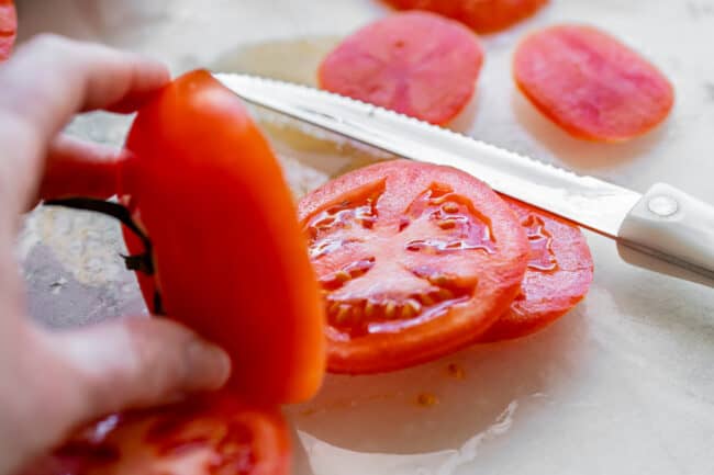 slicing a tomato with a serrated knife