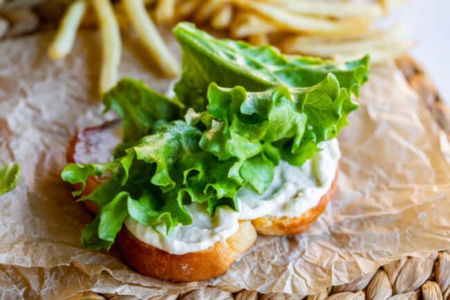 green leaf lettuce on bread with mayonnaise on paper with fries