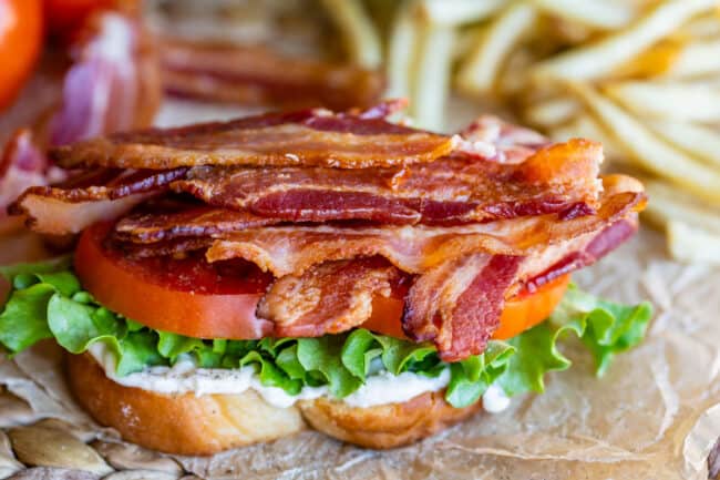 bacon, tomato, lettuce, mayo, white bread, with fries in the background