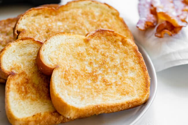 toasted white bread with butter on a white plate