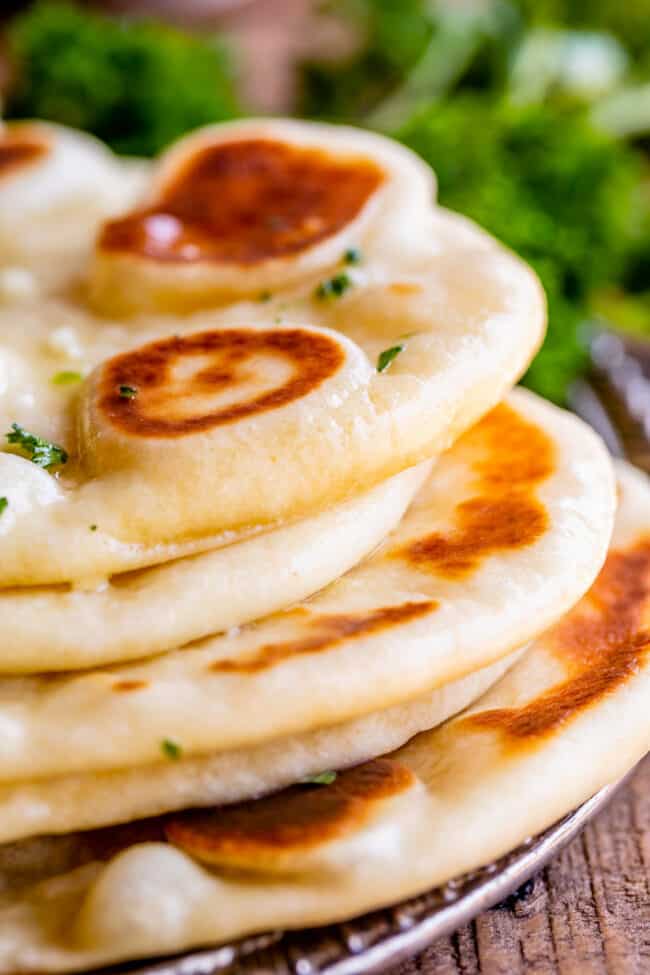 fresh homemade naan bread, stacked up on a plate.