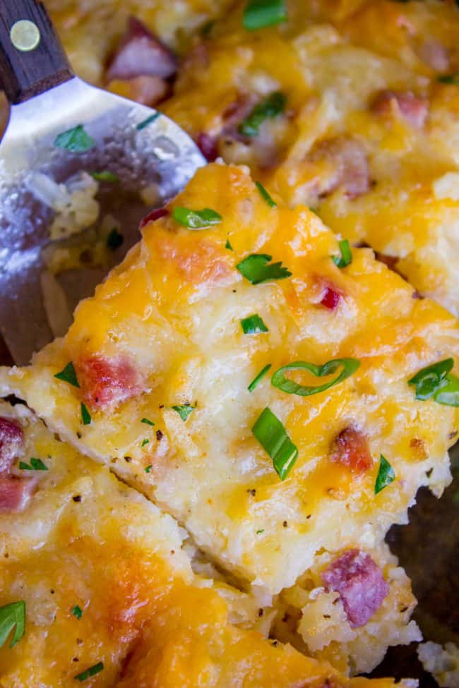 hashbrown breakfast casserole close-up with chives, ham, cheese, and potatoes visible