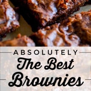 Close-up of thick, fudgy brownies stacked on parchment paper, with melted chocolate chips visible. Text overlay reads: “Absolutely the most delicious brownies I have ever made.”.