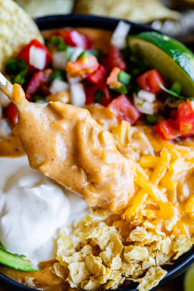 Creamy Chicken Enchilada Soup (Chili's Copycat Recipe) from The Food Charlatan. This dreamy Creamy Chicken Enchilada Soup tastes like the kind at Chili's, only better! It is a simple soup that has a unique flavor thanks to Masa Harina (corn flour). There are no veggies in the soup; instead you make Pico de Gallo and serve it as a generous topping! It's one of my all time favorite soups! #chicken #dinner #recipe #easy #enchilada #enchiladasoup #chickensoup #creamy #cheesy #stovetop #Chilis close up shot of a spoonful of chicken tortilla soup.
