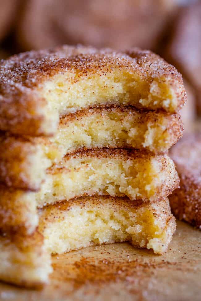 stack of snickerdoodle cookies on a pan, with sprinkled cinnamon.