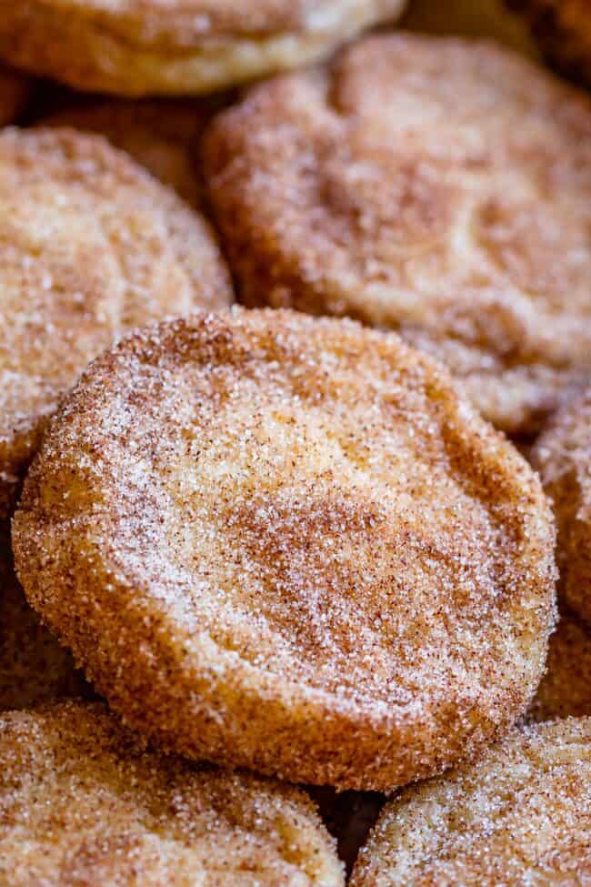 soft and chewy snickerdoodles, stacked on a pan.