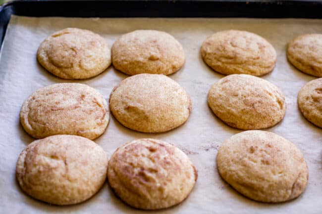snickerdoodle cookies on a pan just out of the oven, still puffy