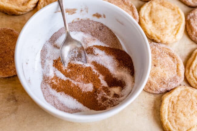 cinnamon and sugar swirled together in a white bowl with a spoon.