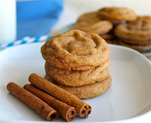 Snickerdoodles on a plate with cinnamon sticks.