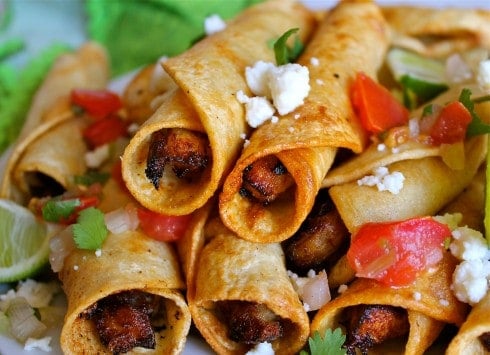 crispy homemade chicken flautas with queso fresco, pico de gallo, and fresh lime. 