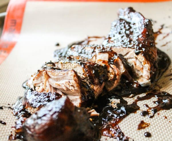 sliced brown sugar balsamic pork tenderloin on a silicone baking mat.