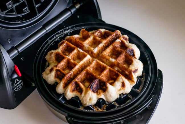 liege waffle cooking in a Belgian waffle iron.