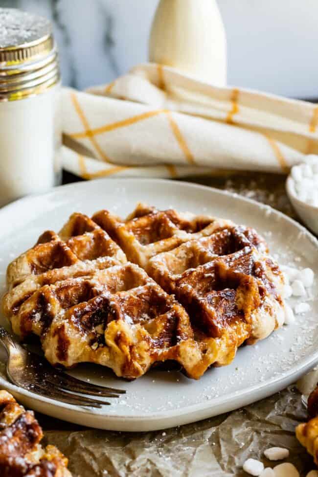 liege waffle on a plate with pearl sugar and powdered sugar.