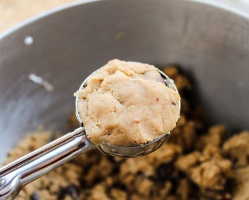 butterscotch caramel cookie dough in a cookie scoop with plain dough patched over a chocolate caramel.
