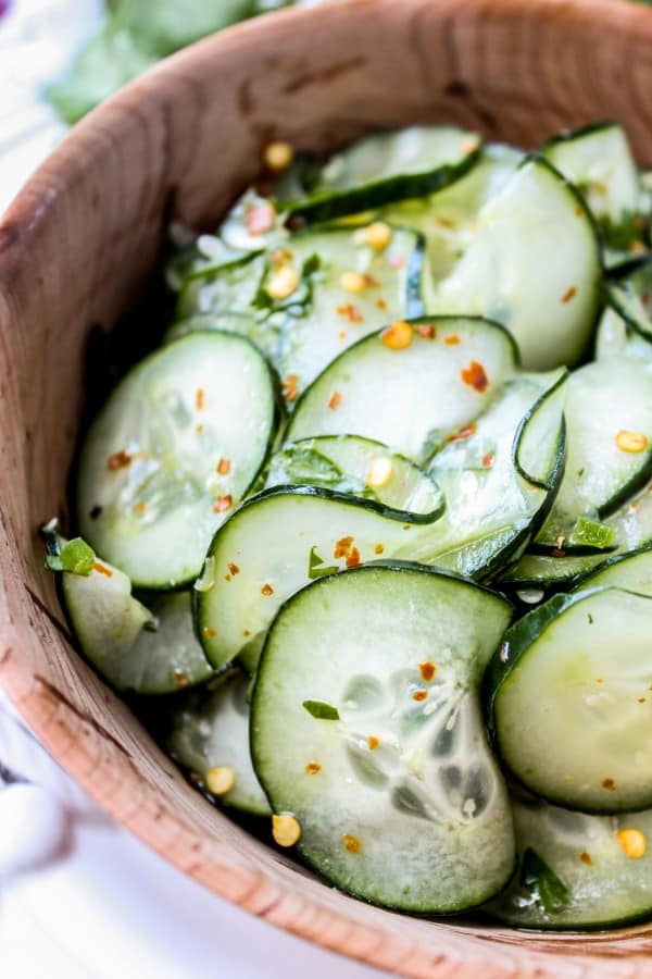 Mexican cucumber salad with cilantro and lime in a wooden salad bowl.