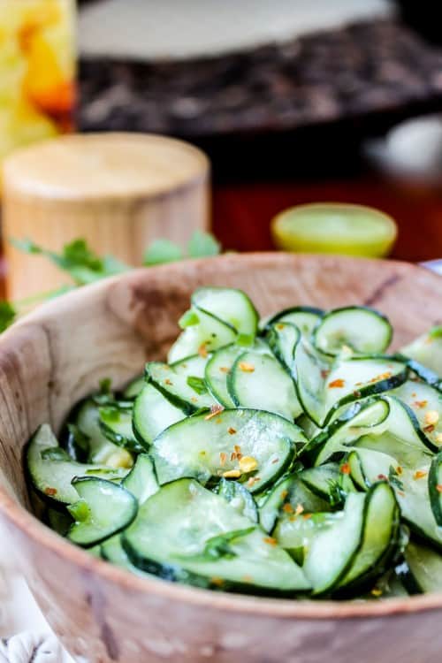 Mexican cucumber salad with cilantro and lime in a wooden salad bowl.