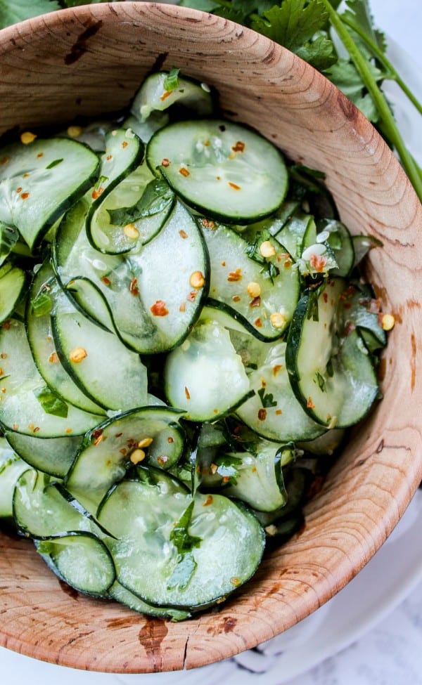 Mexican cucumber salad with cilantro and lime in a wooden salad bowl.