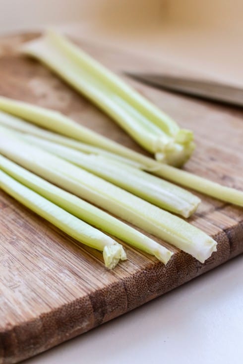 celery ribs on a wooden cutting board for making meatloaf. 