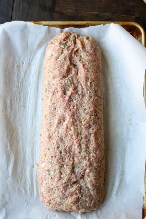 meatloaf shaped and ready to bake on a parchment lined baking sheet.