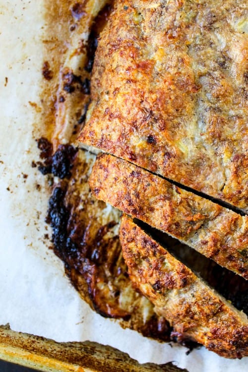 meatloaf sliced on a parchment lined baking sheet.