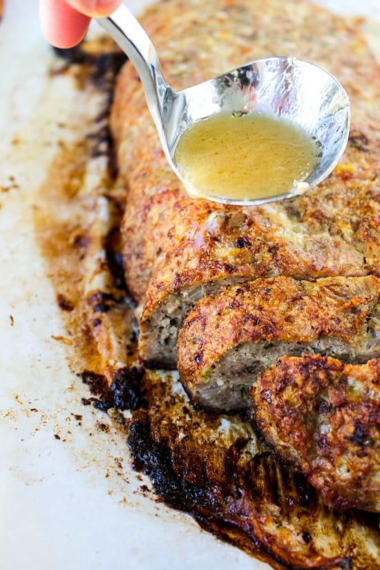 meatloaf with garlic sauce being ladled onto it. 