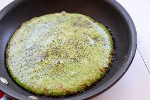 cooking spinach and eggs, blended together, in a frying pan. 