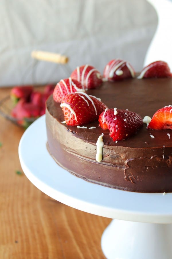 Chocolate frosted strawberry truffle cake with sliced strawberries covered in glaze.