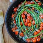 asparagus and cherry tomatoes in a cast iron skillet.