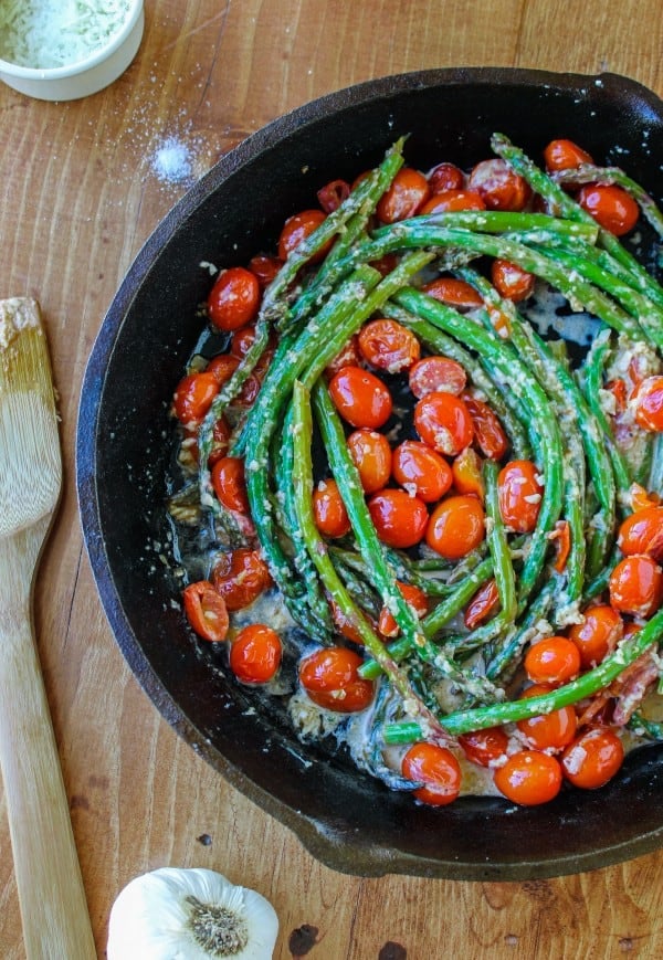 asparagus and cherry tomatoes in a cast iron skillet. 