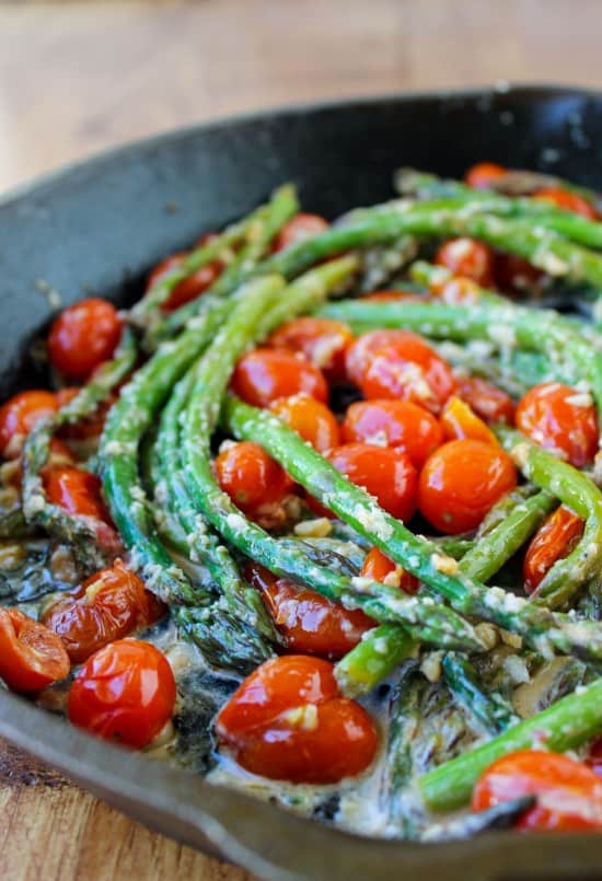 asparagus and cherry tomatoes in a cast iron pan. 