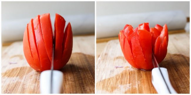 slicing a small tomato on a cutting board with a paring knife.