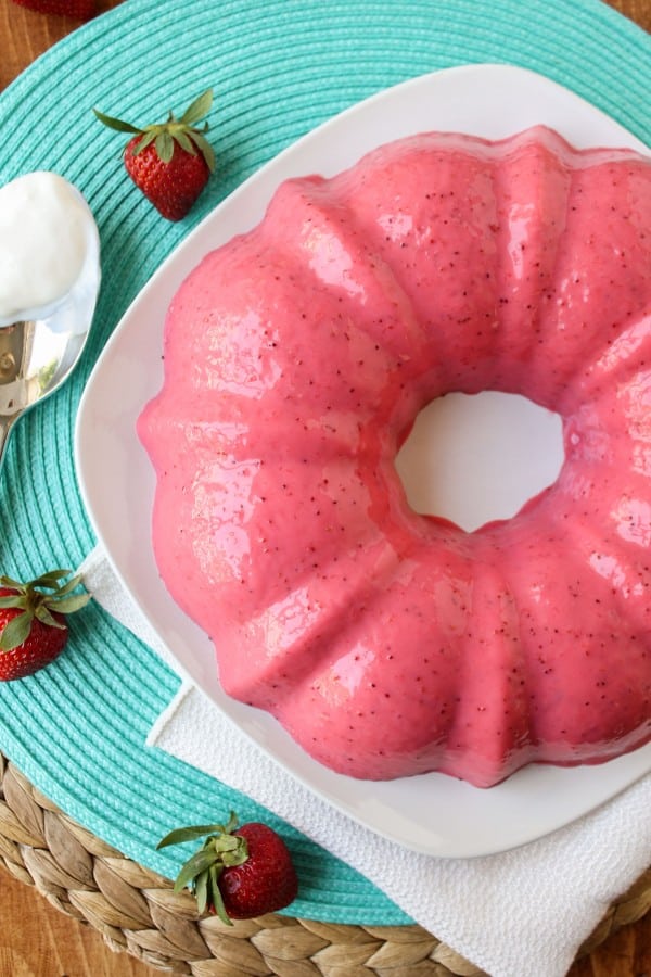 Creamy Strawberry Banana Jello formed in a mold on a white plate.