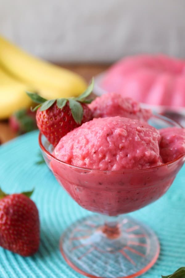 Strawberry banana jello scooped into a princess glass ice cream dish.