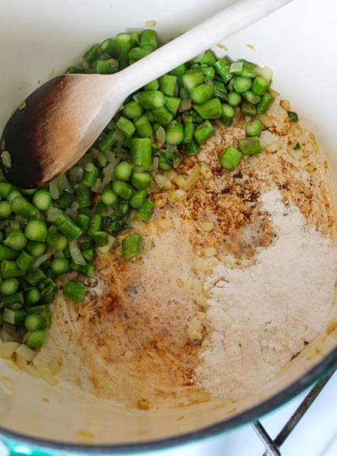 making a roux in part of a pot with asparagus on the other side.