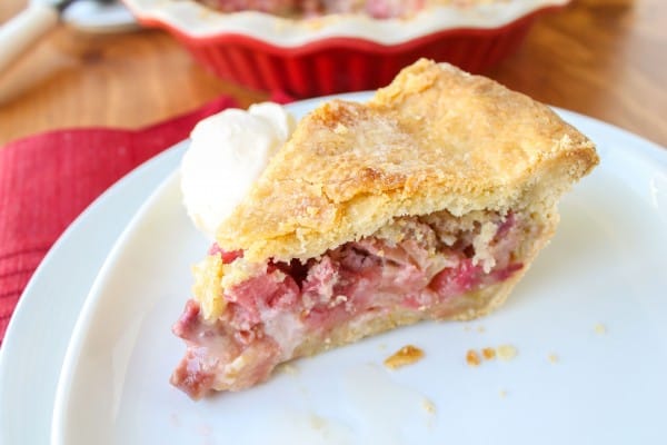 a slice of rhubarb custard pie with ice cream on a plate.